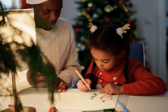 papa-regardant-sa-fille-dessiner-un-arbre-de-noel