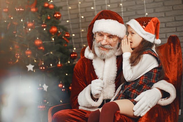 petite-fille-chuchotant-dans-loreille-du-pere-noel